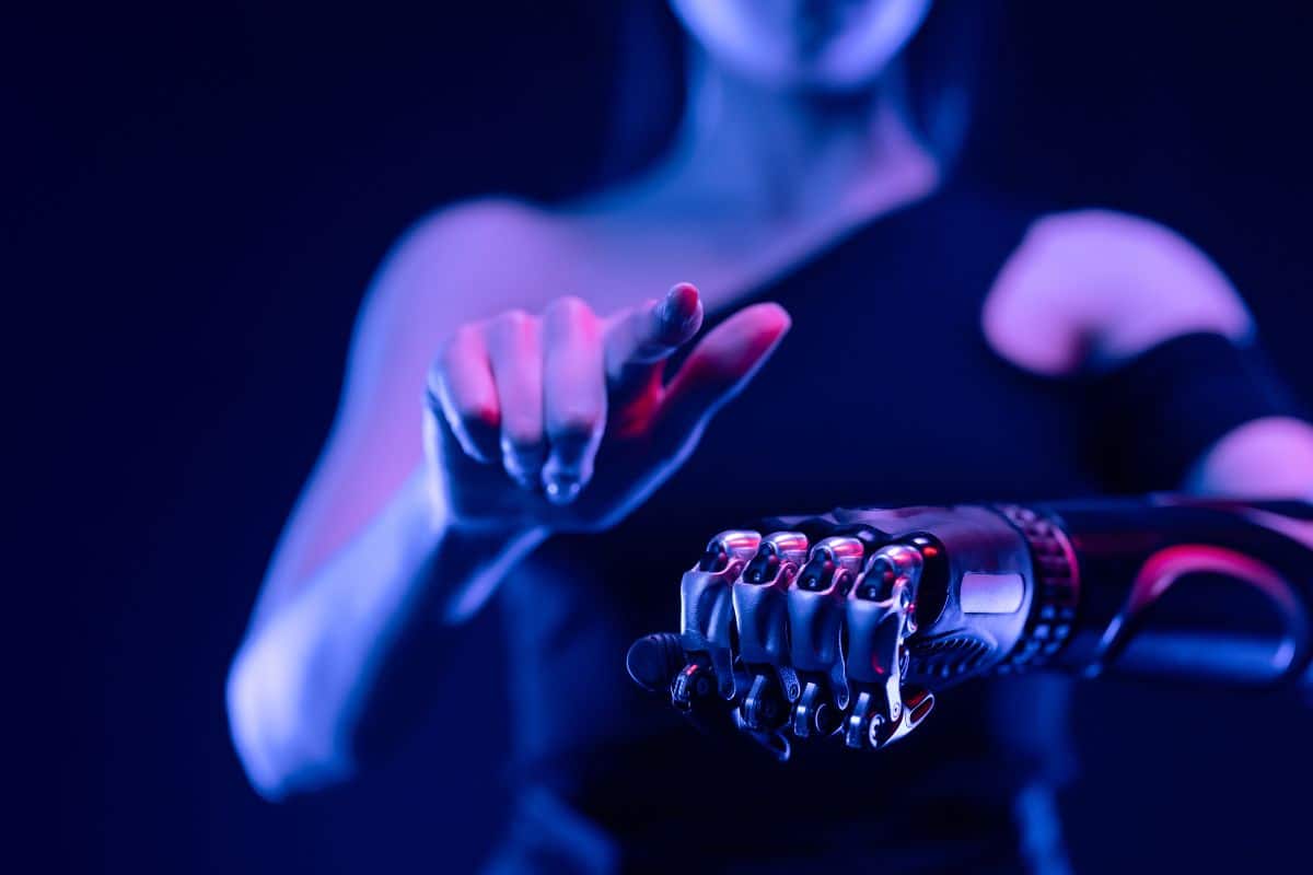 Main cybernétique sous éclairage néon.