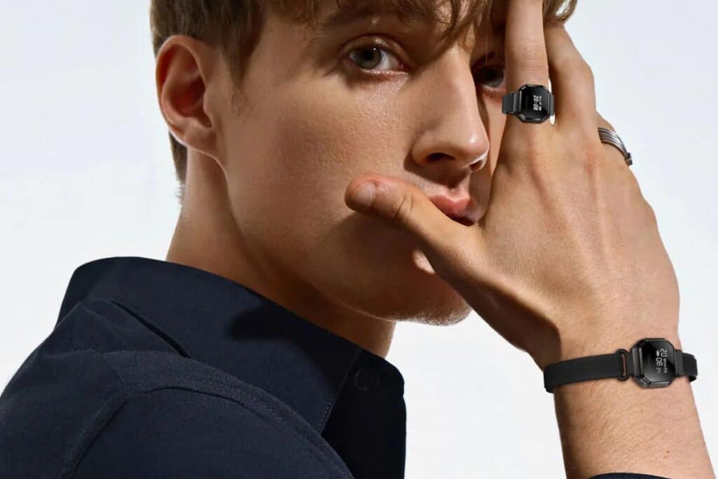 Homme portant montre et bague noires élégantes.