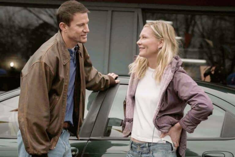 Deux personnes discutant près d'une voiture.