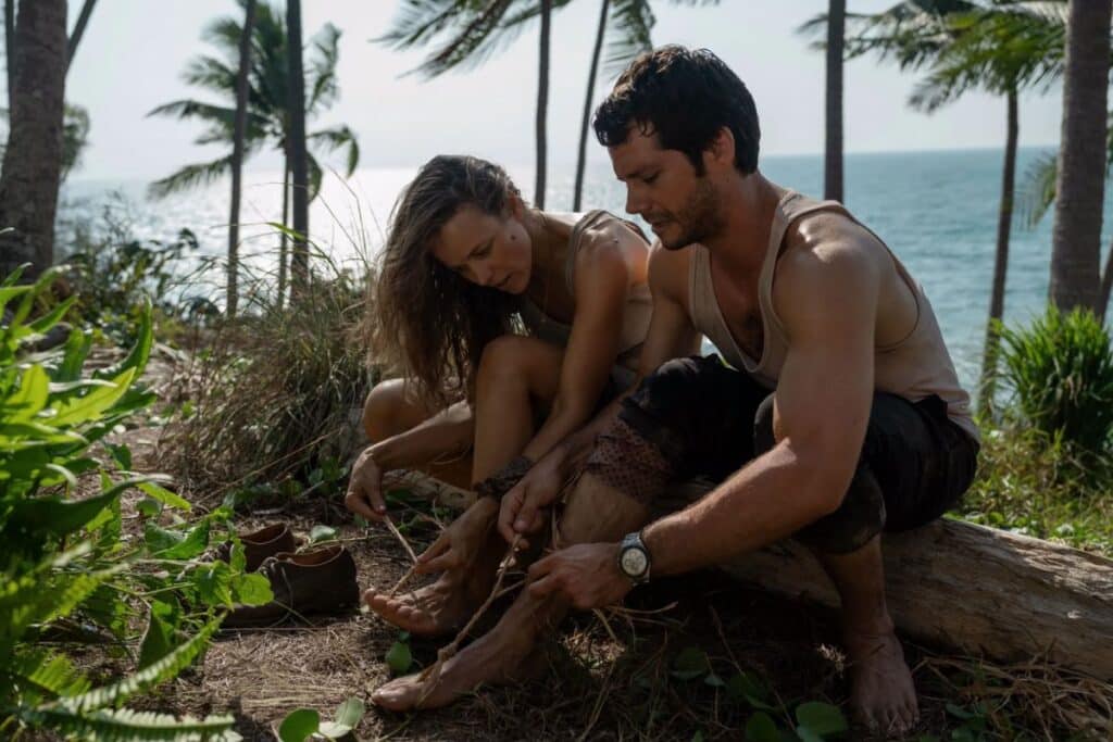 Deux personnes assises sur une plage tropicale.
