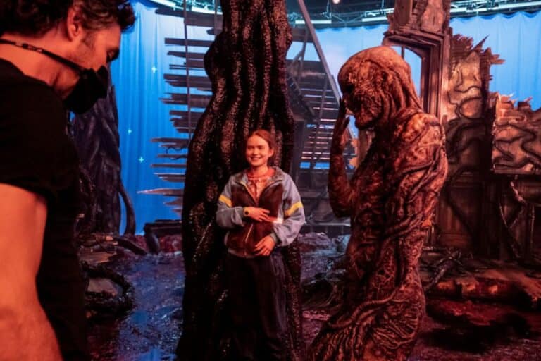 Personnes sur un plateau de tournage avec décor fantastique.