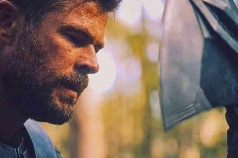 Homme barbu pensif avec hache en arrière-plan.