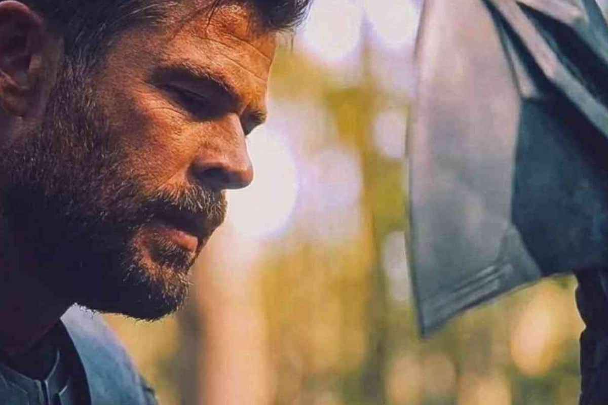 Homme barbu pensif avec hache en arrière-plan.