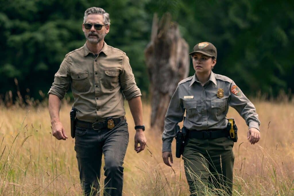 Deux personnes en uniforme marchant dans un champ.