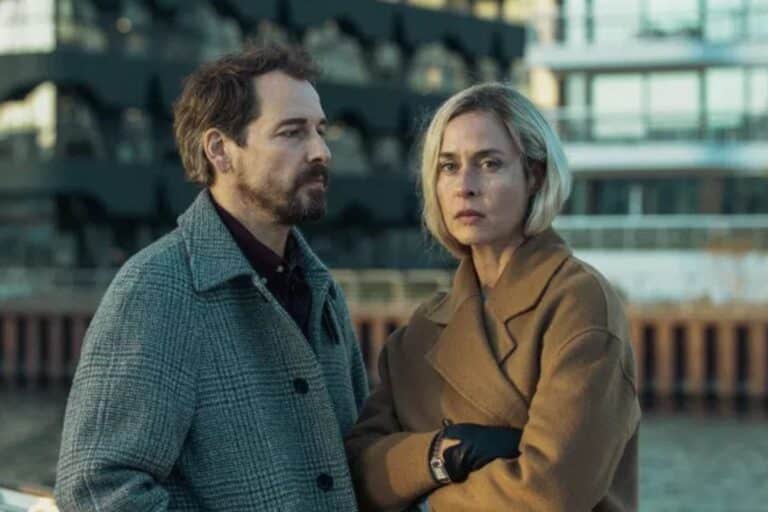 Deux personnes vêtues de manteaux devant un bâtiment.