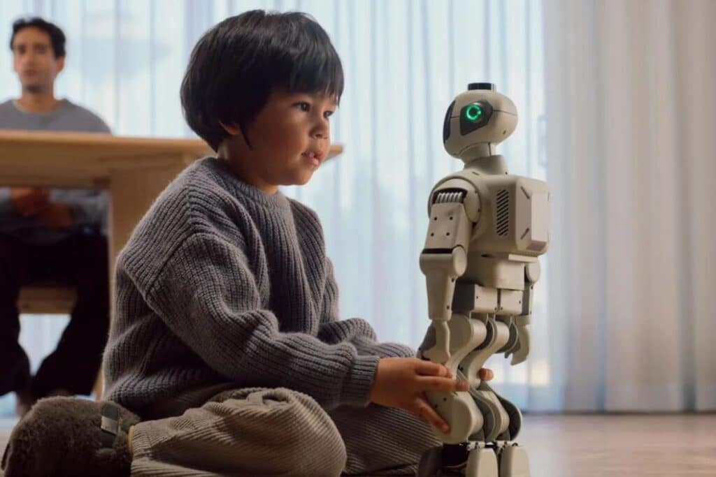 Enfant jouant avec un petit robot humanoïde.