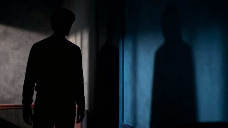 Silhouette d'une personne projetant une ombre sur un mur.