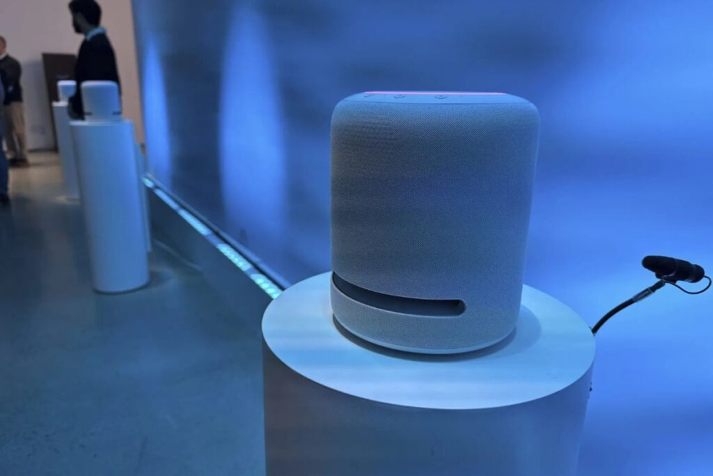 Haut-parleur cylindrique sur un socle blanc.