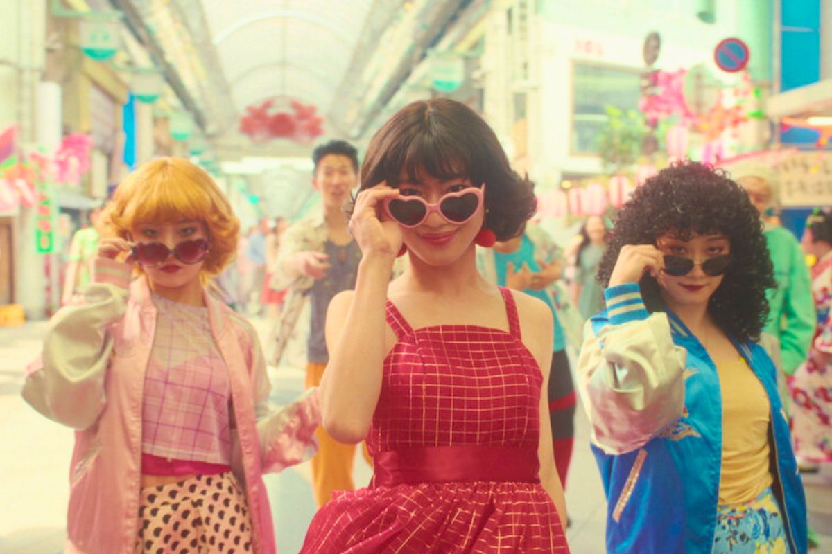Trois femmes souriantes portant des lunettes de soleil.