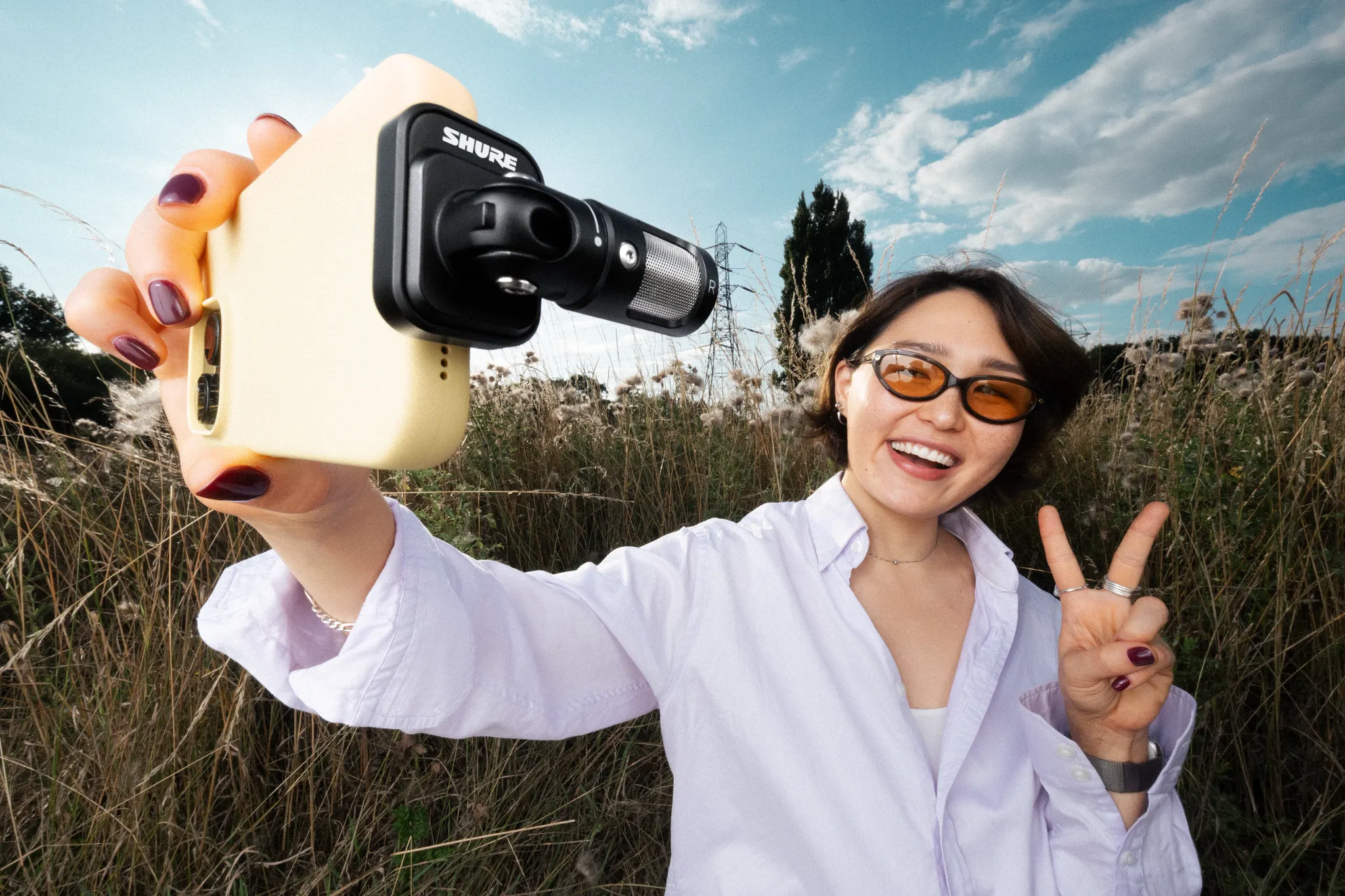 Personne prenant un selfie avec micro, extérieur.
