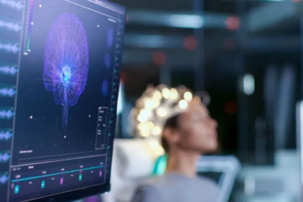 Analyse cérébrale sur écran, patient en arrière-plan.