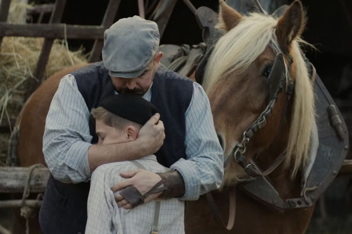 Homme et enfant s'étreignent près d'un cheval marron.
