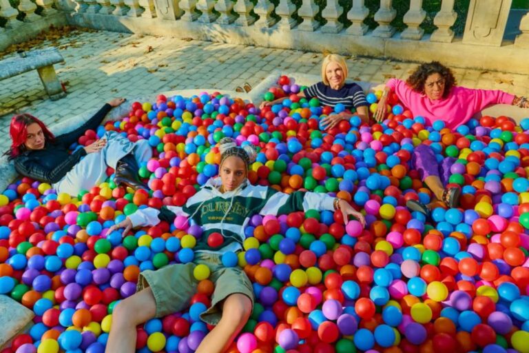 Quatre personnes dans une piscine de balles colorées.