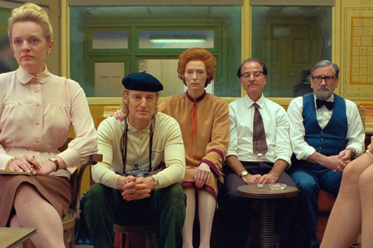 Cinq personnes assises dans une salle.