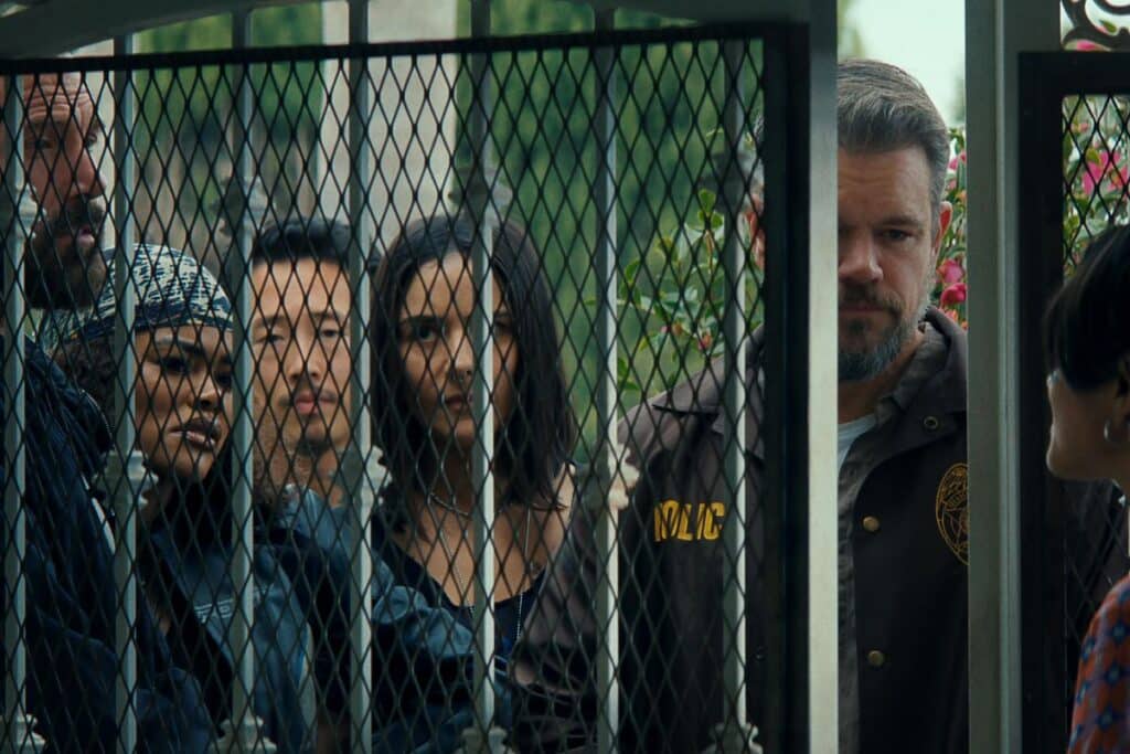 Groupe de personnes derrière une grille.