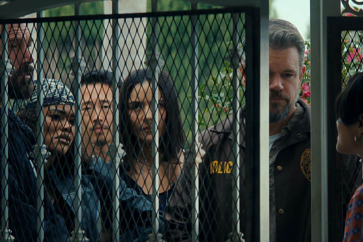 Groupe de personnes derrière une grille.