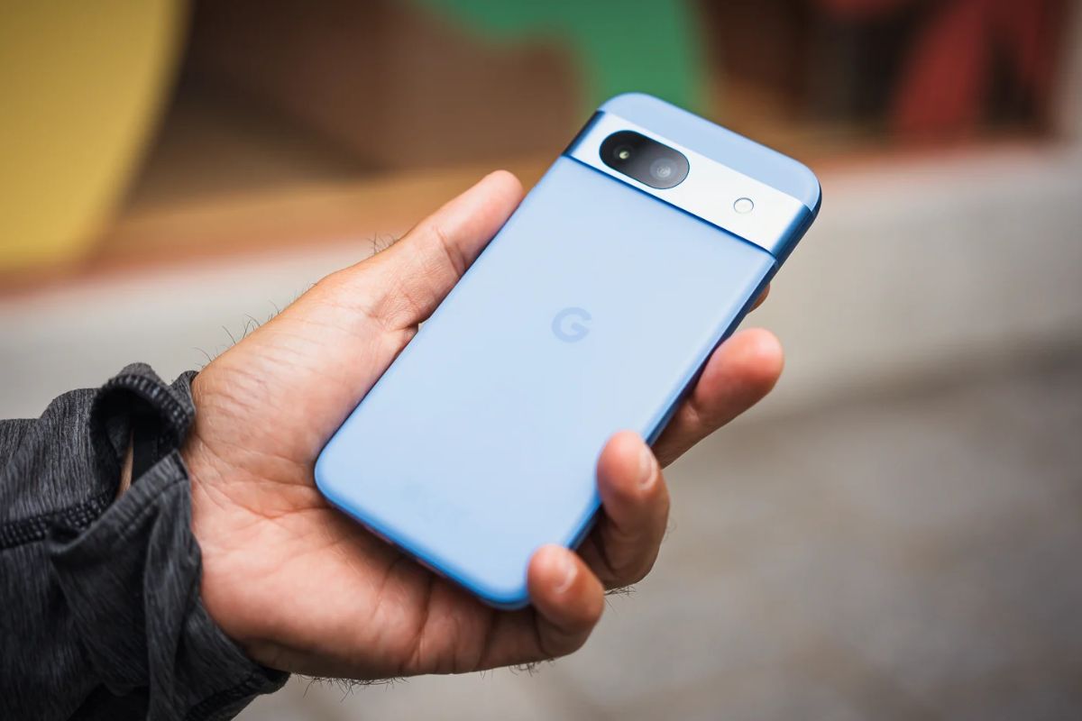 Homme tenant un smartphone bleu de dos.